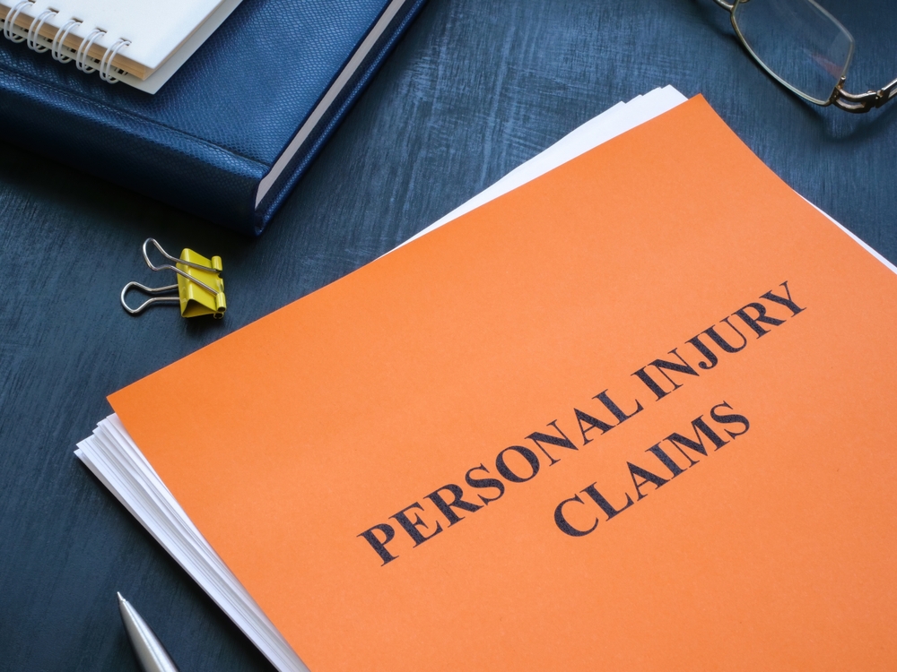 A stack of papers with personal injury claims on the table