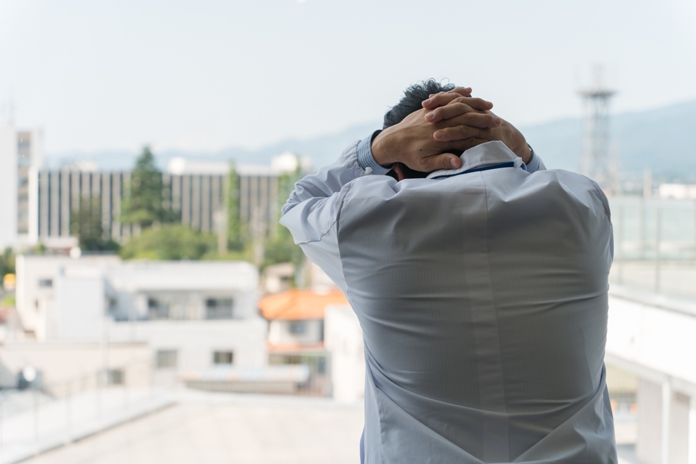 Male doctor holding his head