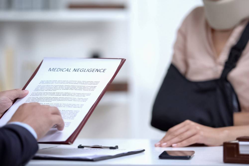 Insurance agent signing Medical negligence to accident victim with broken hand