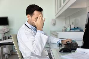 Doctor looks stressed due to medical errors or misdiagnosis